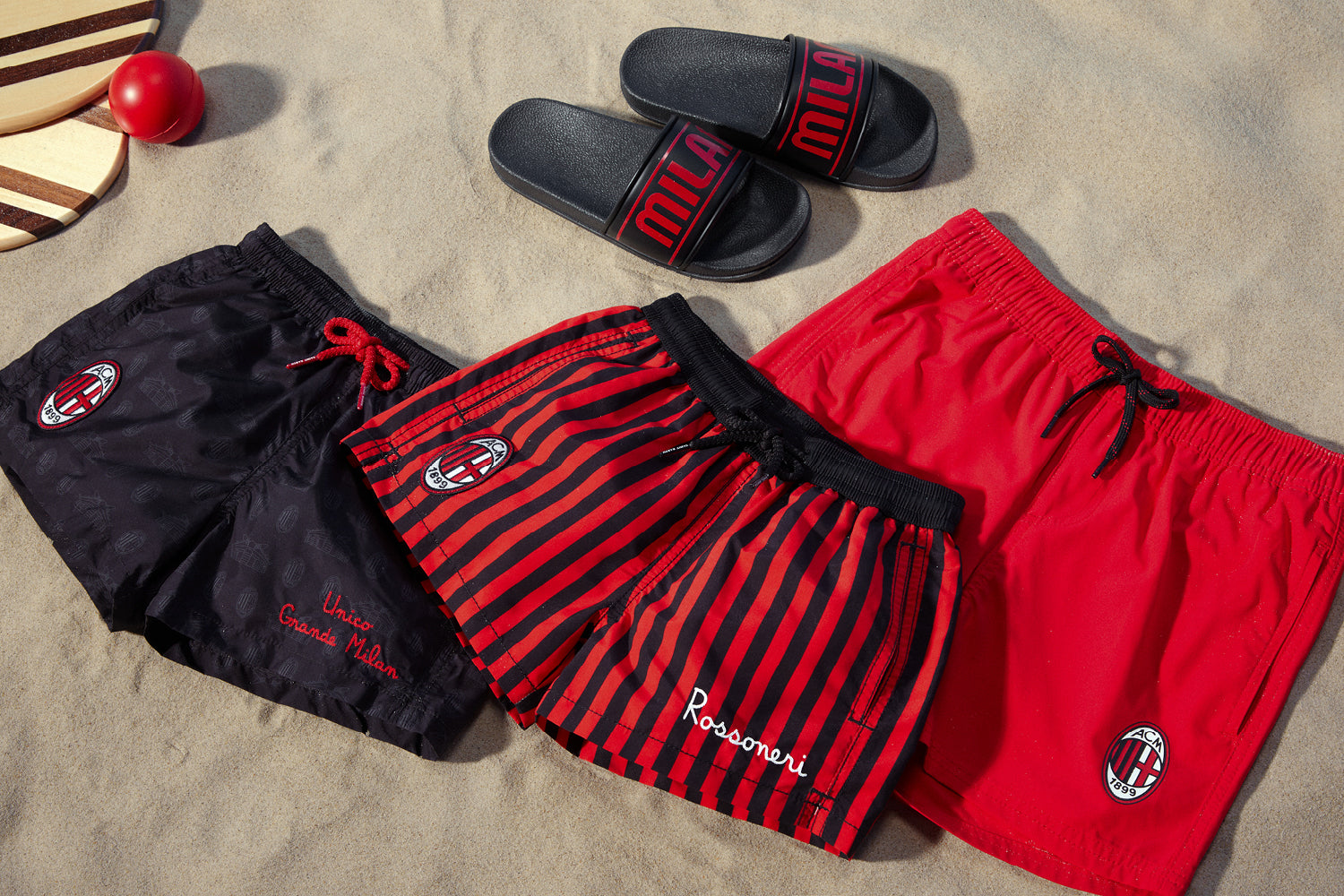 Costumi e accessori mare AC Milan con sabbia